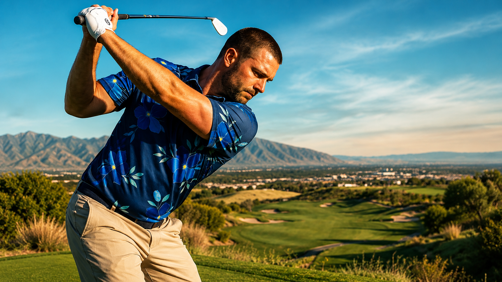 Man playing golf on a scenic course with mountains in the background