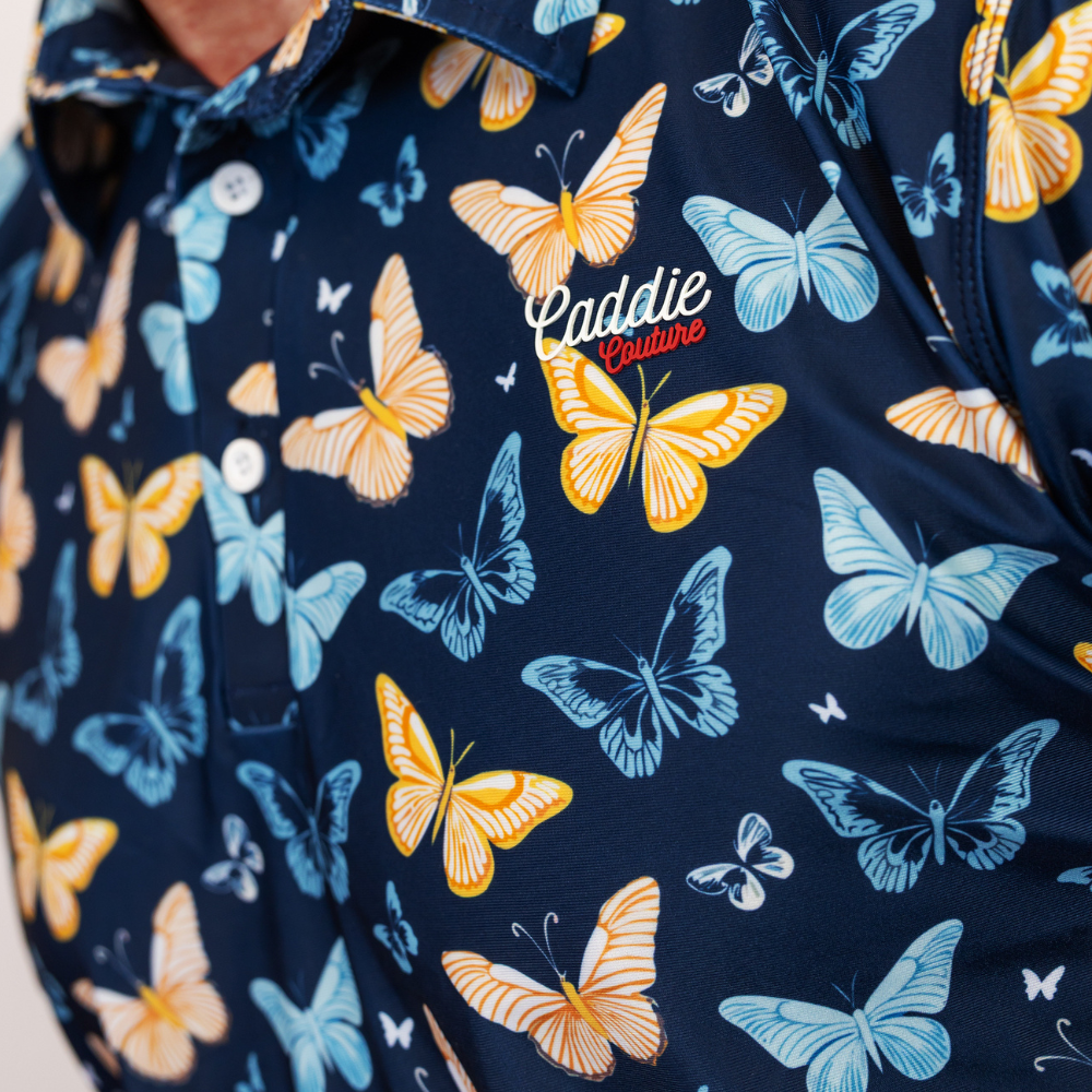Navy blue shirt with colorful butterfly pattern and 'Caddie Couture' branding.