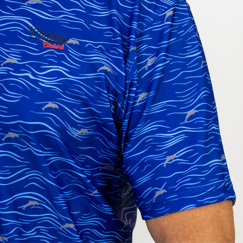 Blue golf polo with wave and dolphin pattern on a white background