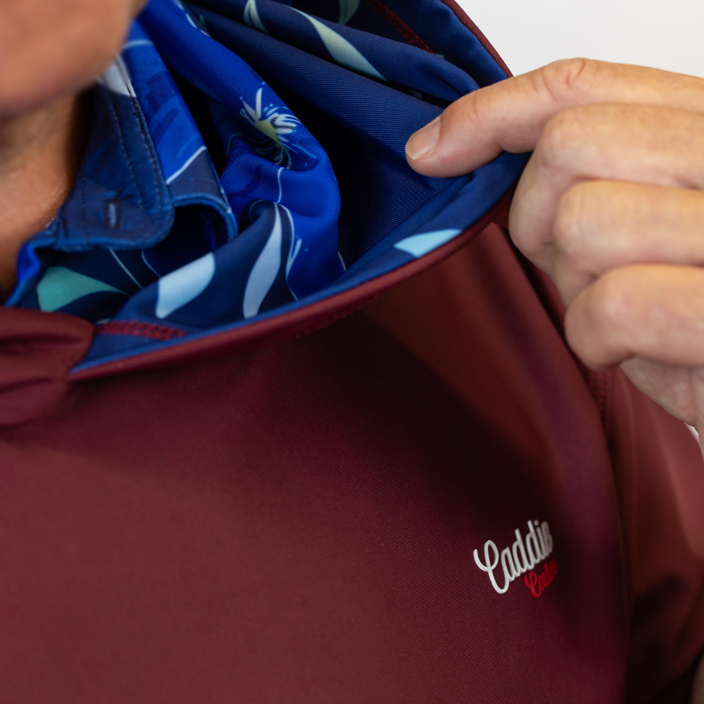 Red bag with 'Caddie' logo being held open to reveal blue fabric inside.