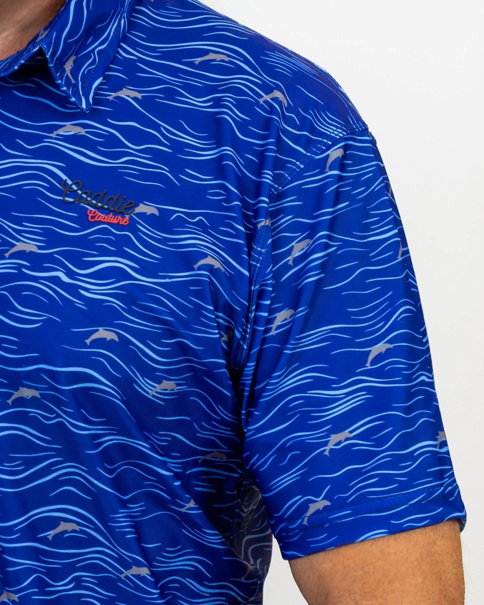 Blue patterned Golf shirt with a Caddie Couture logo on a grey background