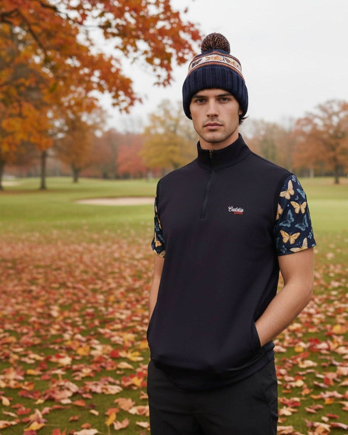 Man wearing a navy golf vest with butterfly sleeves in an autumn park