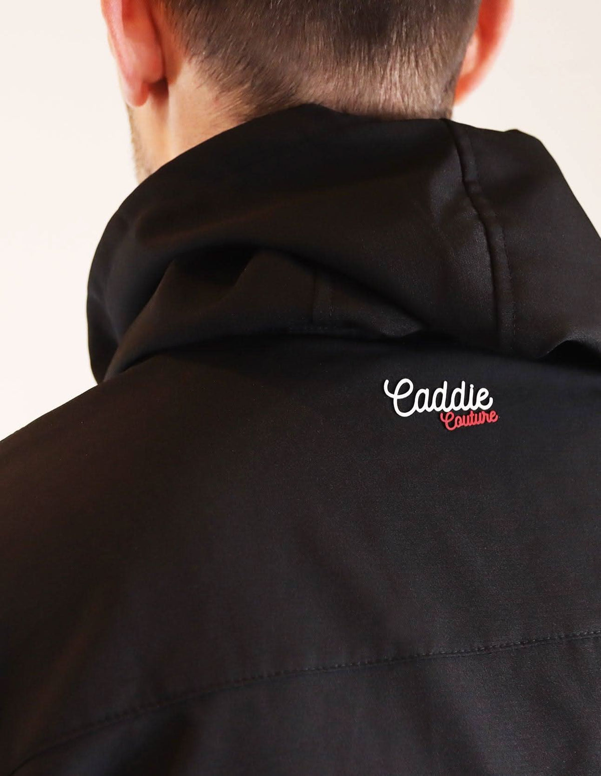 Black jacket with 'Caddie Couture' logo on a plain background