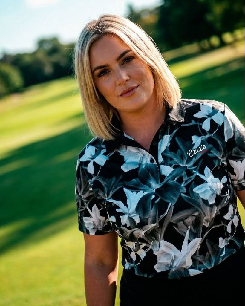 Woman in a floral shirt standing outdoors with a blurred background