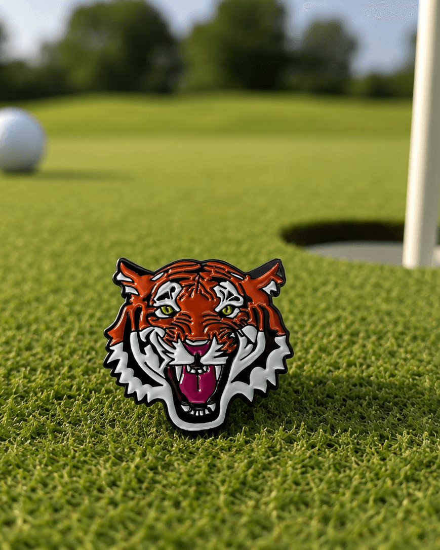 Golf ball and tiger head marker on a golf course with a hole in the background