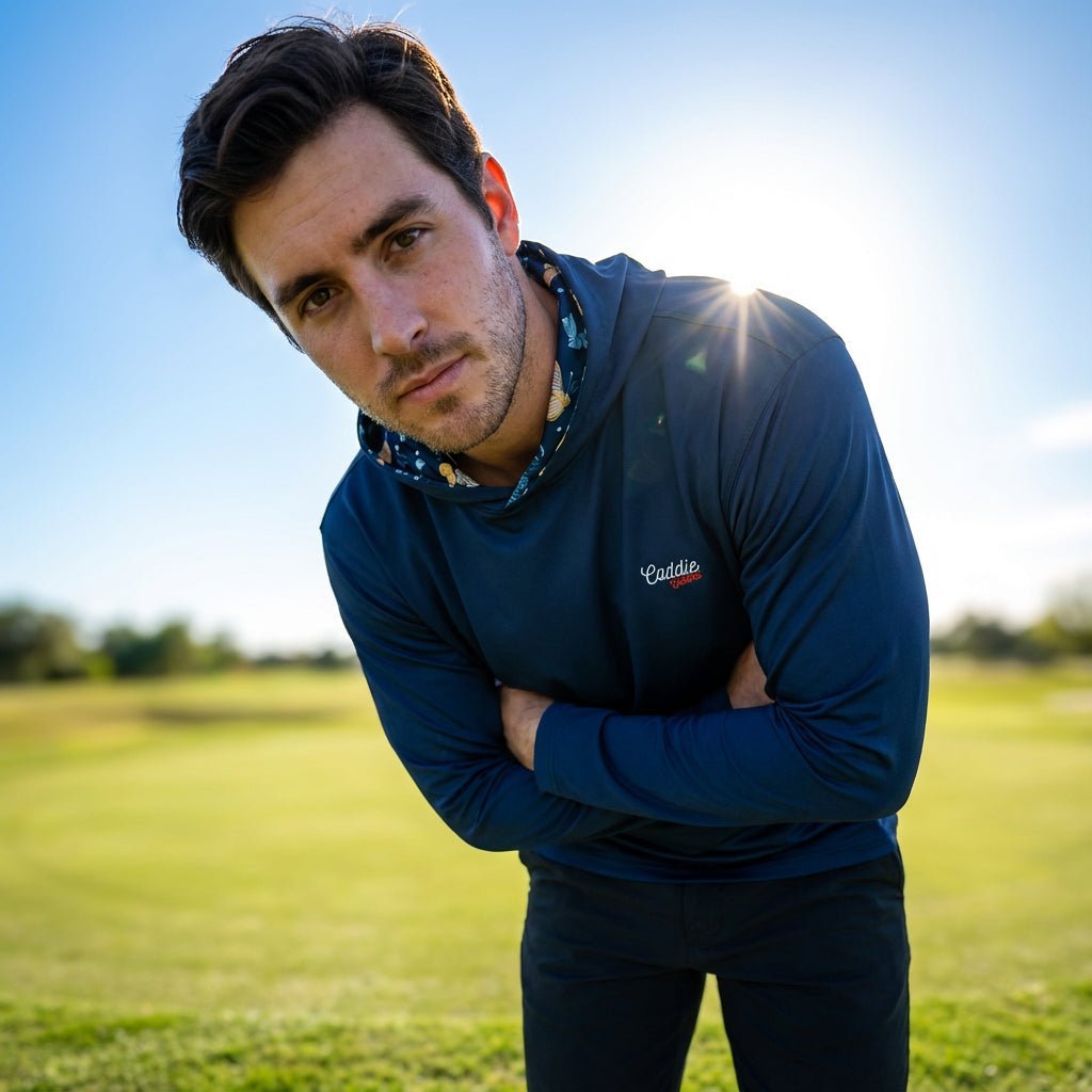 Man bending over looking into camera on golf course. wearing Caddie Couture Golf Hoodie