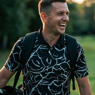 man wearing green golf polo looking at the camera