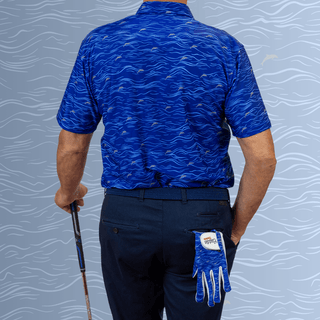 Man Wearing Blue wave pattern golf polo with back to camera. Holding a golf club.