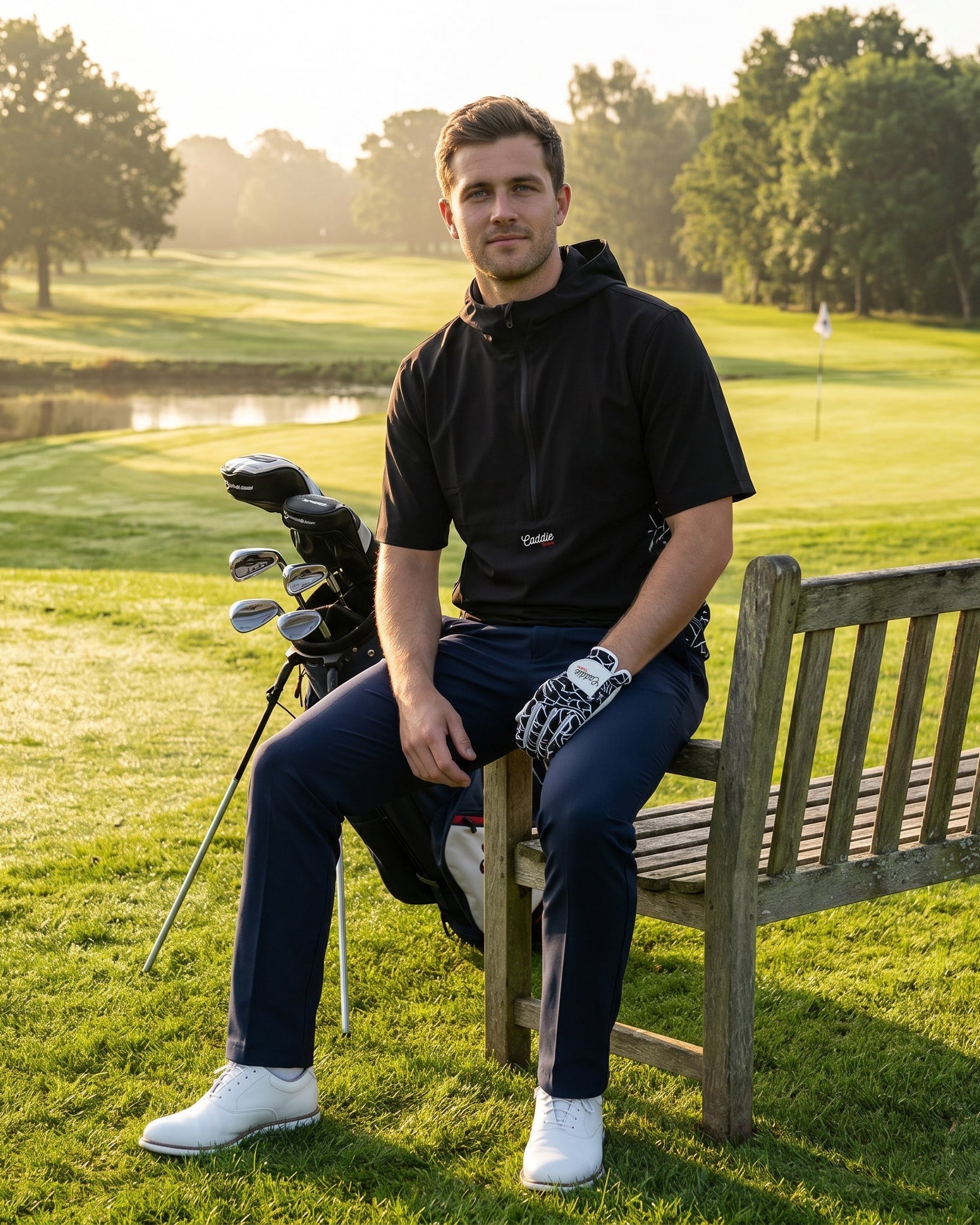 man sitting on a bench on a golf course wearing a windbreaker shirt
