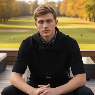 man wearing windbreaker shirt sitting on a bench at a golf course