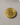 Gold Bitcoin coin on a gray surface with a golf ball in the background