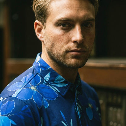 close up of man wearing blue floral petal golf polo