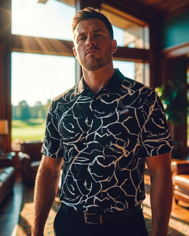 Man wearing a patterned shirt in an indoor setting with a view of a golf course.
