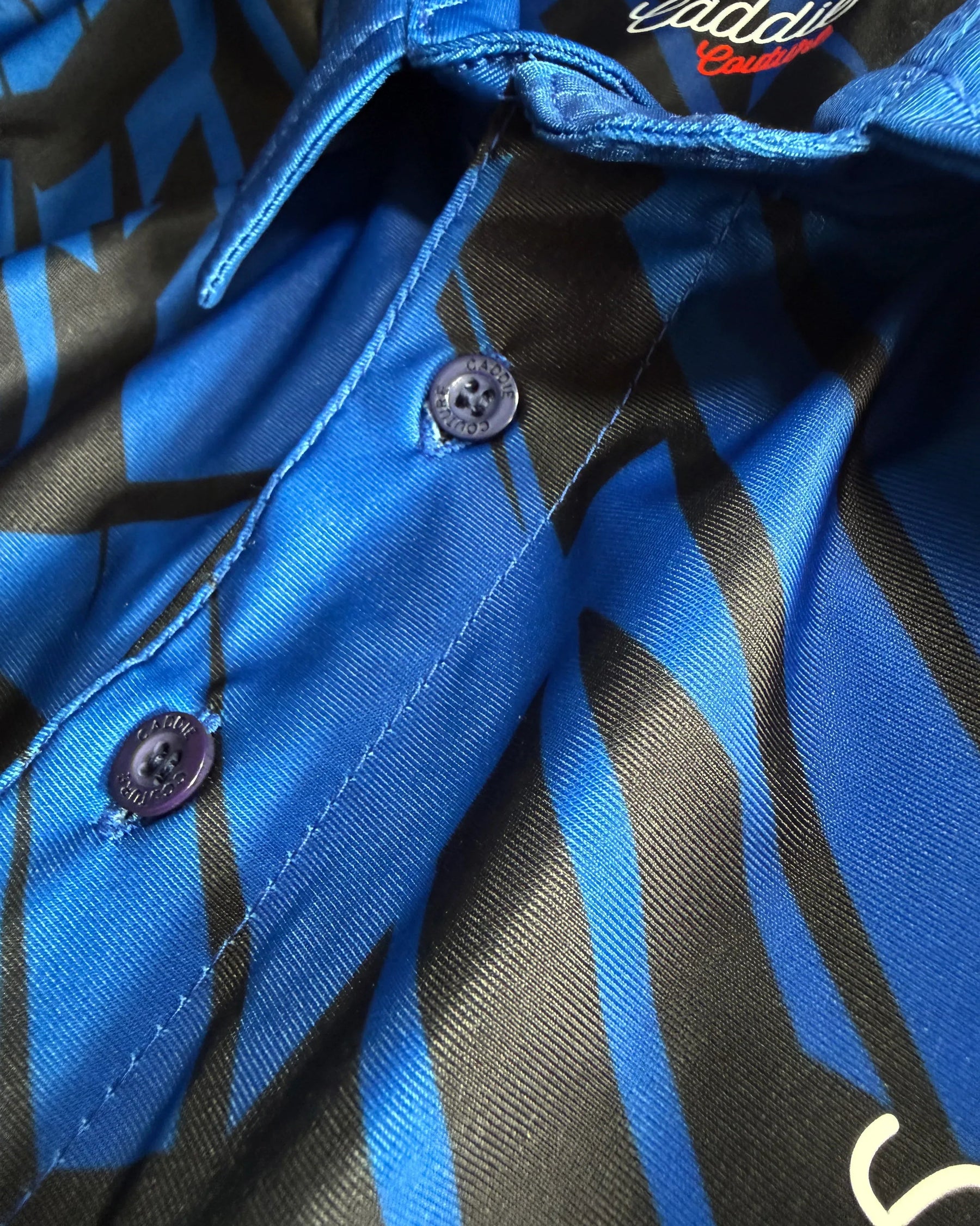 Close-up of a blue and black patterned shirt with buttons.