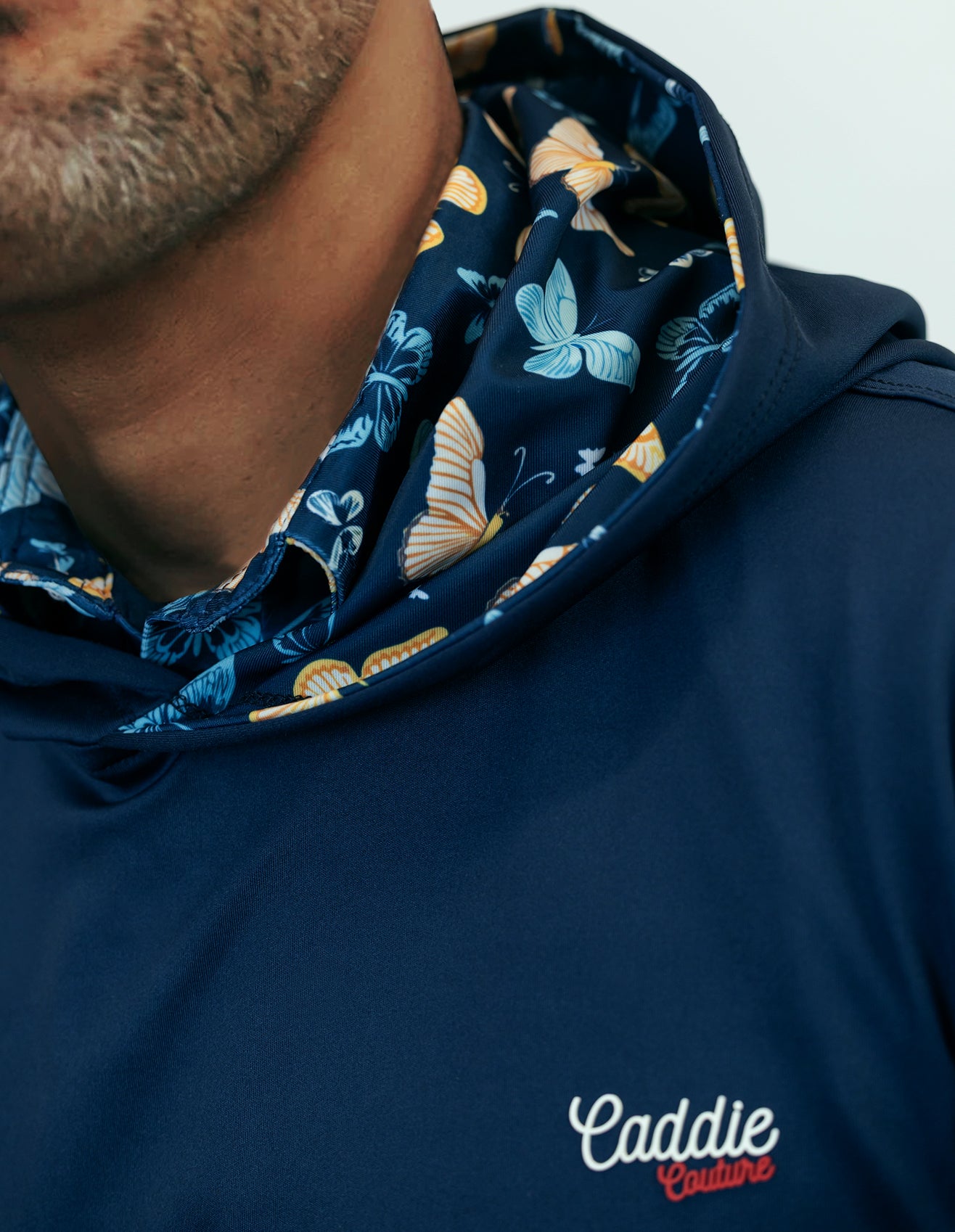Navy blue hoodie with floral pattern on hood and 'Caddie Couture' branding.