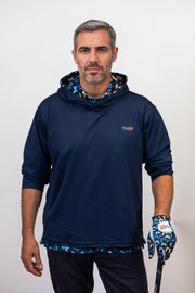 Man wearing a navy blue hoodie with a brand logo, holding a golf club and glove.