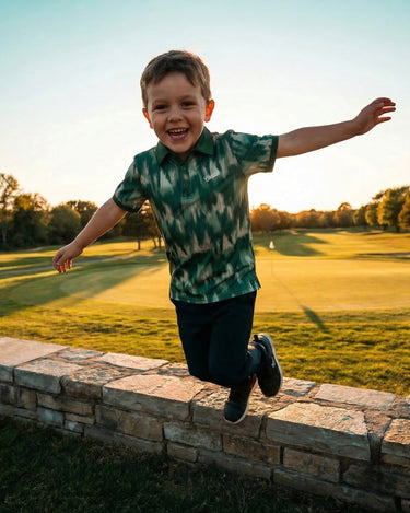 Child running on a stone wall with a golf course and trees in the background