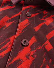 Close-up of a button-front shirt with a bold red and dark brown abstract brushstroke pattern, dark buttons, and visible collar stitching.