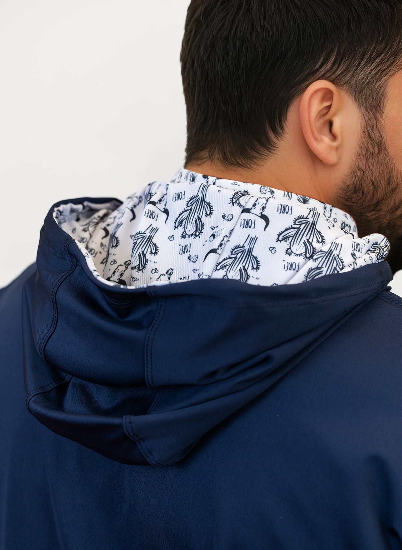 Navy blue golf hoodie with a patterned hood lining on a plain background