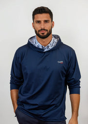 Man wearing a navy blue golf hoodie with a patterned lining on a white background