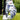 Golf glove with blue and white pattern holding a golf ball on grass