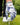 Golf glove with blue and white pattern holding a golf ball on grass