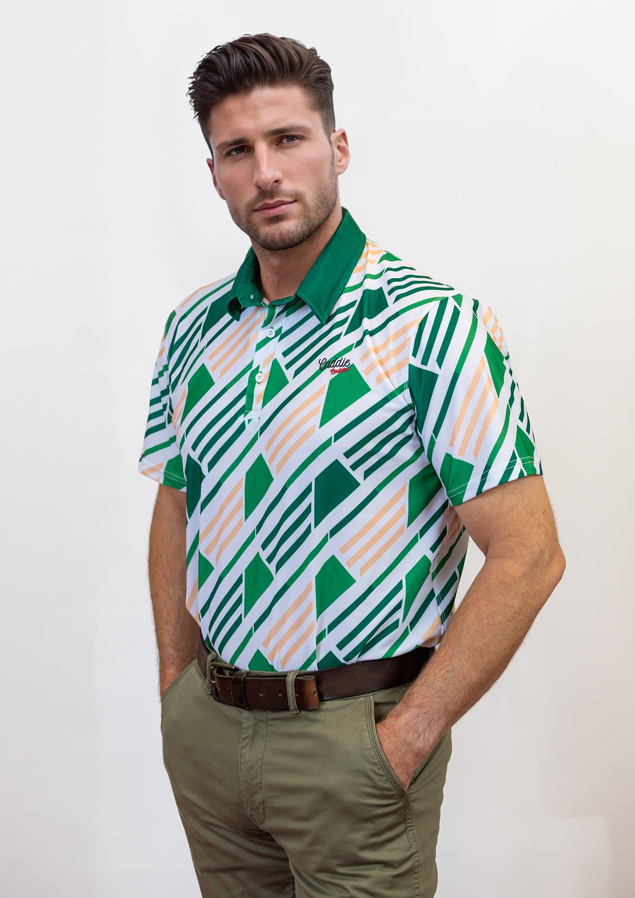 Man wearing a patterned golf shirt with geometric design on a plain background