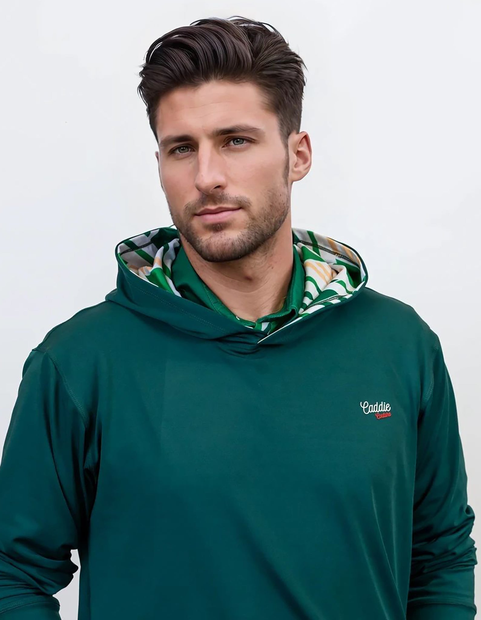 Man wearing a green golf hoodie with a brand logo on a white background