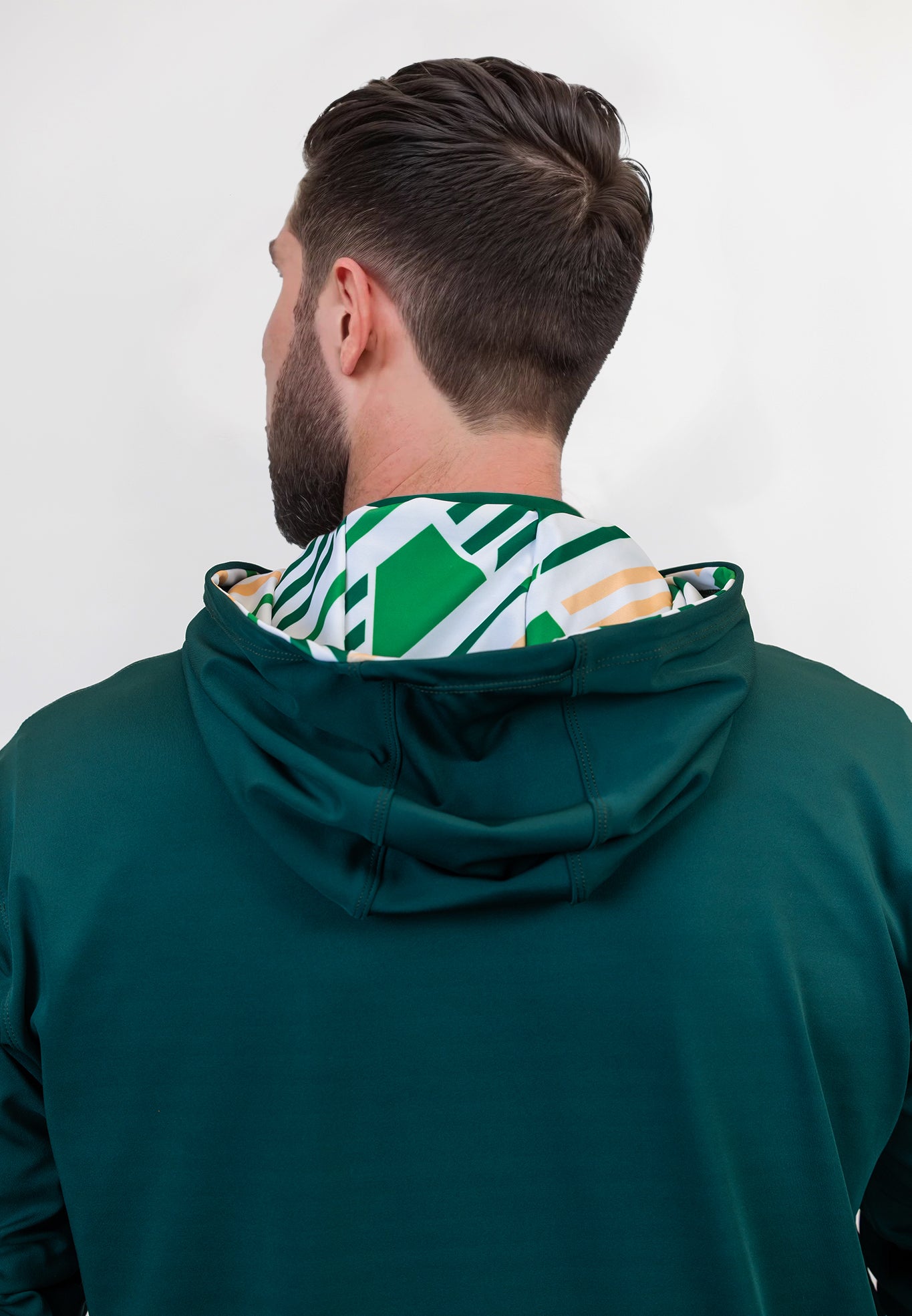 Person wearing a green golf hoodie with a patterned hood against a white background