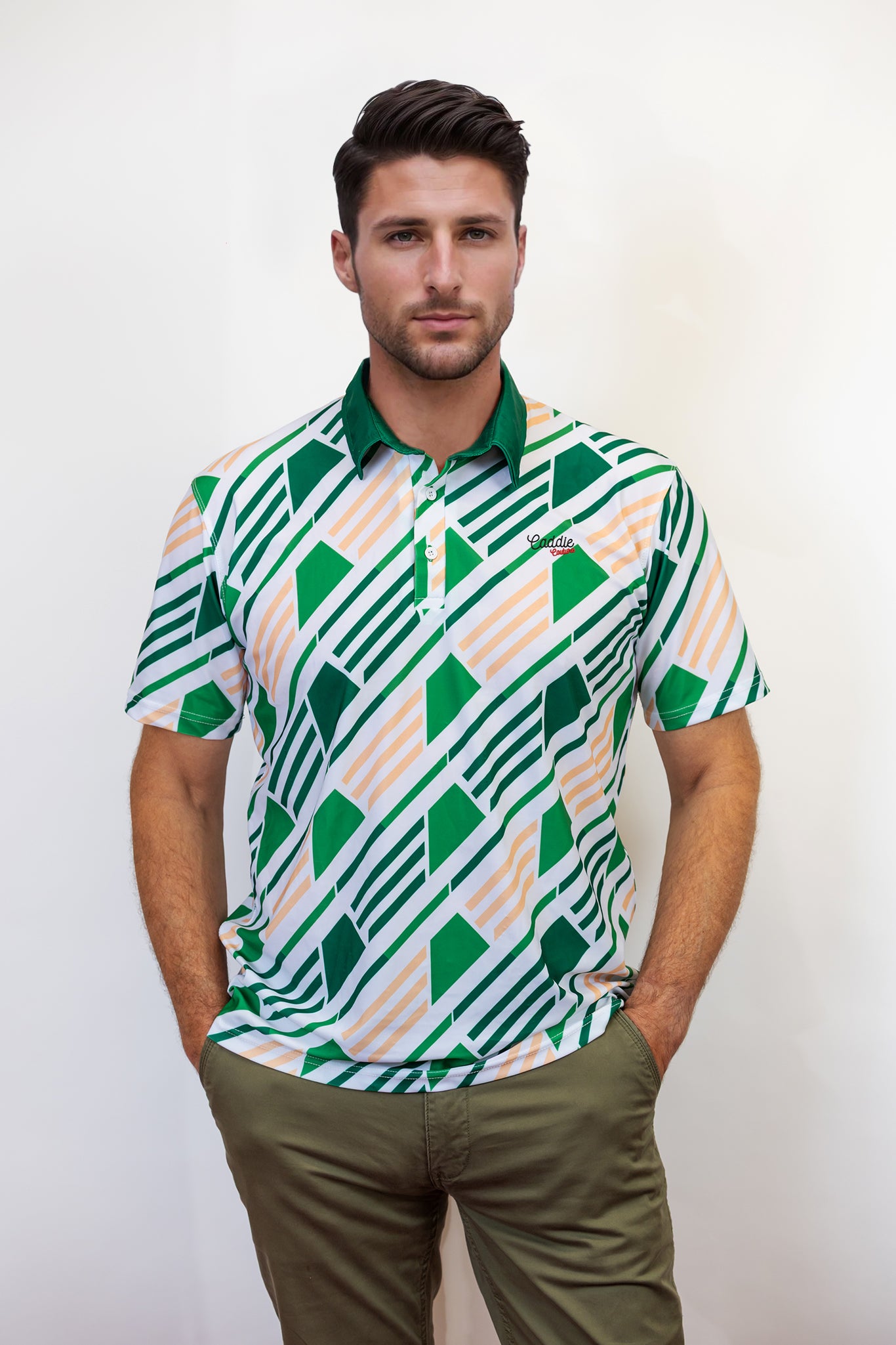 Man wearing a patterned green and white golf shirt with a plain background
