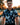 Man wearing a patterned shirt with a blurred outdoor background