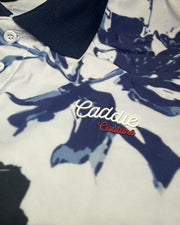 Close-up of a polo shirt with floral pattern and 'Caddie Couture' branding.