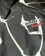 Close-up of a GOLF POLO with 'Caddie Couture' branding on a camouflage pattern.