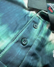Close-up of a green camouflage-patterned bag with a button and brand logo.