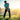 Man playing golf on a grassy field with a scenic background