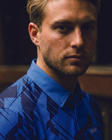 close up of man on a side view earing midnight geo golf polo