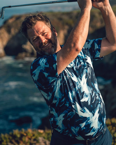 Man playing golf with a scenic background