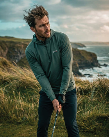 Man playing golf on a coastal cliffside with ocean view