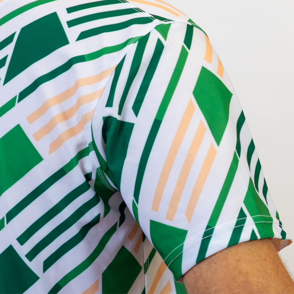 Close-up of a shirt with green and orange geometric pattern on a white background