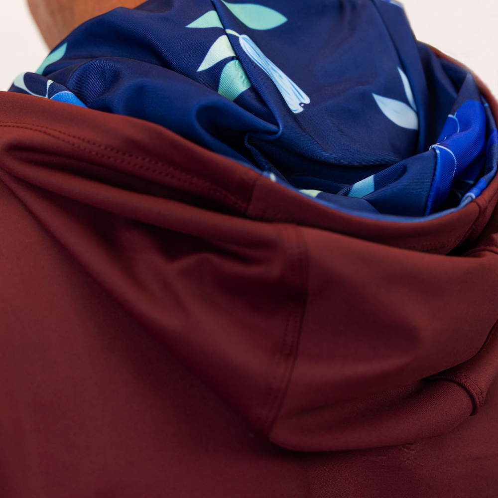 Close-up of maroon and navy hoodies with leaf patterns.