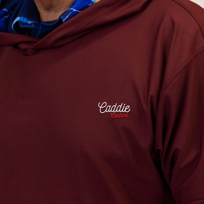 Maroon hoodie with 'Caddie Couture' logo on a plain background