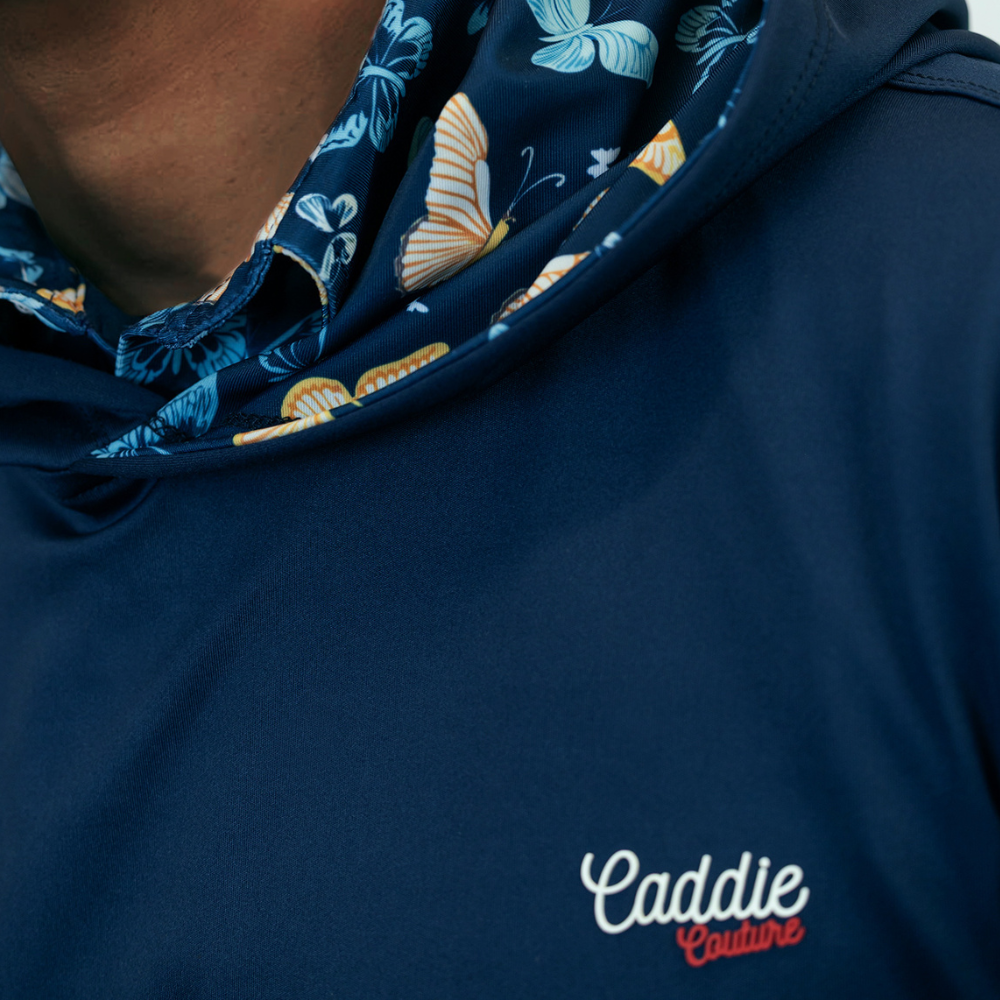 Navy blue garment with floral patterned hood and 'Caddie Couture' branding.