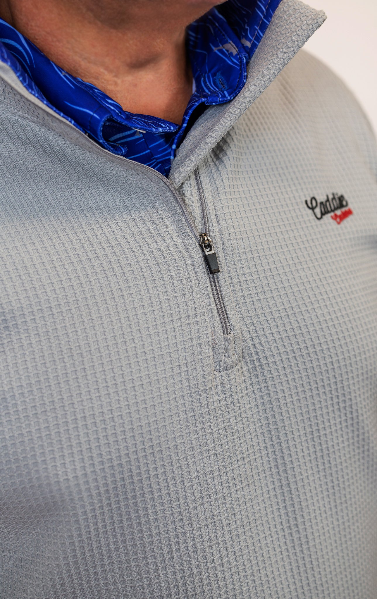Man wearing golf quarter zip with blue wave pattern in neck