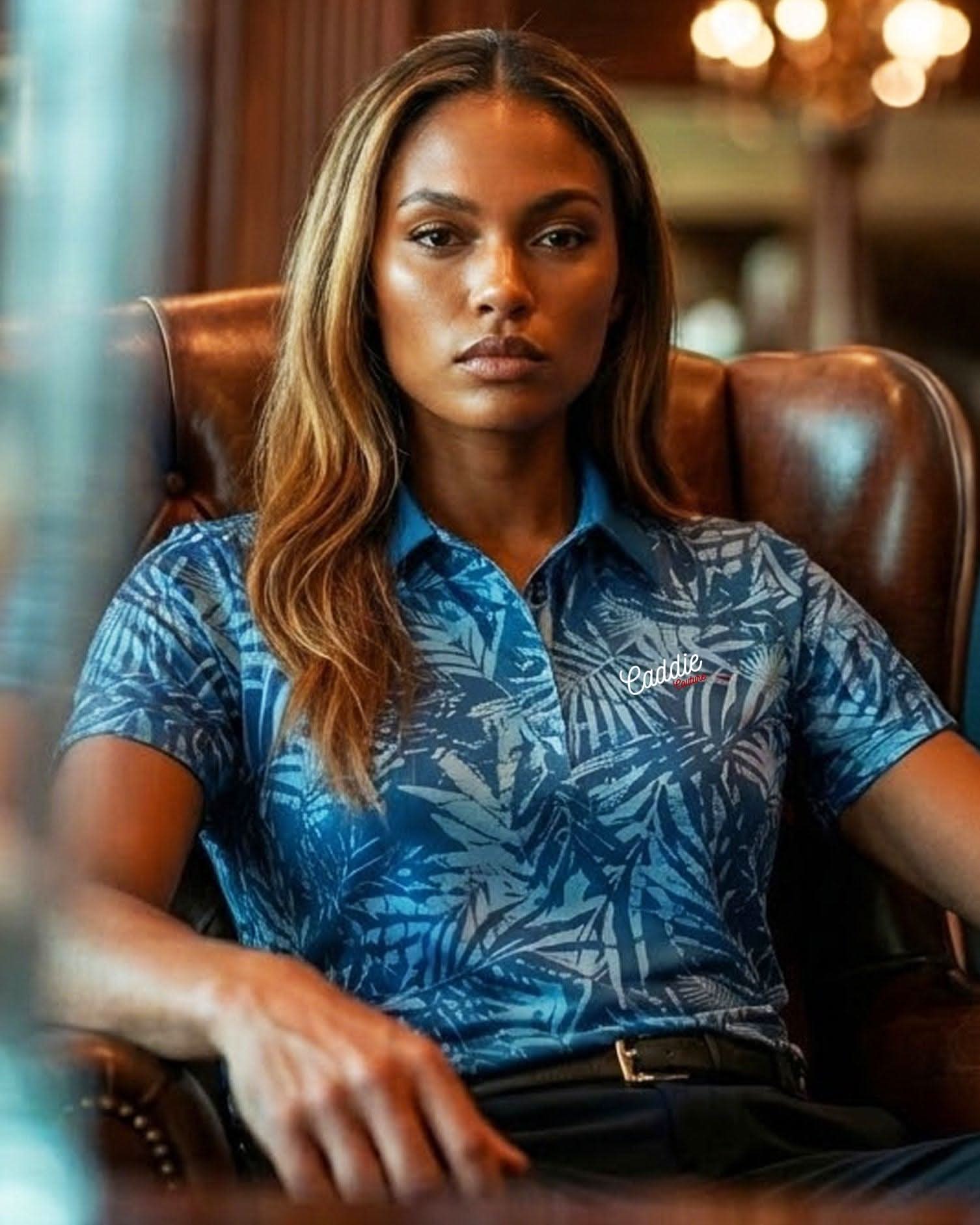 Woman wearing a blue patterned shirt sitting in a chair.