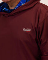 Maroon golf hoodie with 'Caddie' logo on a neutral background