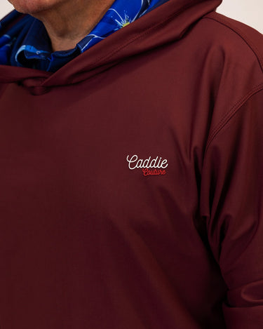 Maroon golf hoodie with 'Caddie' logo on a neutral background