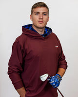 Man wearing a maroon hoodie with a blue inner lining, holding a golf club.