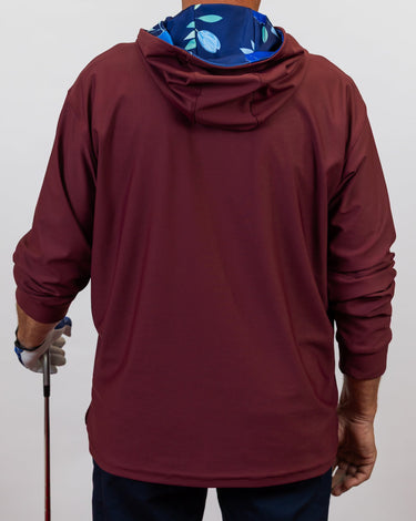 Maroon golf hoodie worn by a person on a plain background