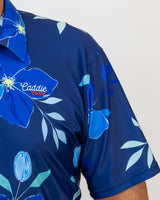 Navy blue golf shirt with floral design and 'Caddie Couture' branding on a white background
