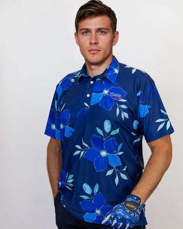 Man wearing a blue floral patterned golf shirt with a golf club on a white background